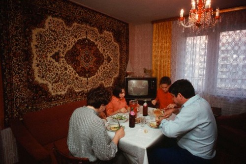 0008rd05-500x334 En bedrestillet familie ved maden, bemærk tæpper på væggen